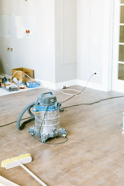 A couple placing labeled boxes into a clean, simple living room as they get ready for moving day.